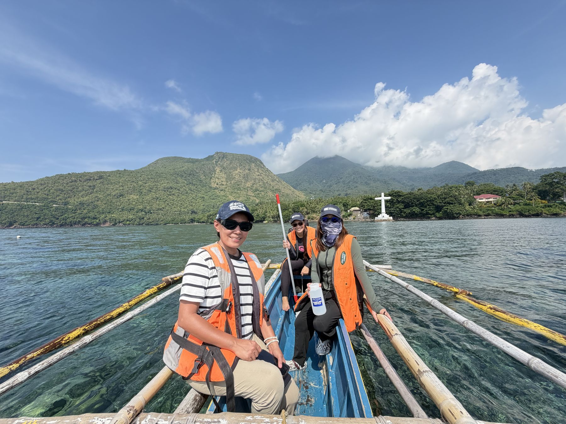 A picture taken by a Bantay Dagat in his bangka showing three members of the Iligan Bay team en route for sampling at sea along the Sunken Cemetery. Camiguin Island, Philippines, September 2026.